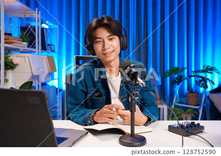 Man speaking into microphone during podcast 128752590