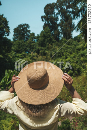 Woman in Straw Hat Admiring Tropical Forest View 128752920