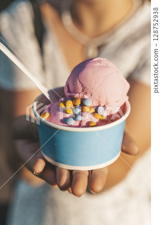 Strawberry Ice Cream Cup with Sprinkles in Hand at City Park 128752938