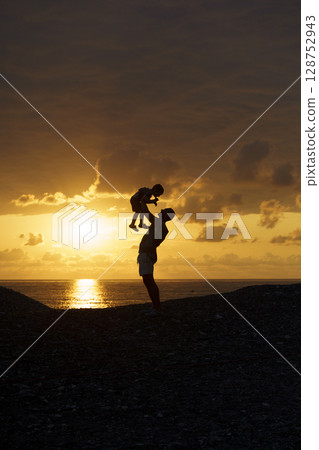 Father and Son Silhouettes at Sunset. Family Bonding Moment Father and Son Silhouettes at Sunset. Family Bonding Moment 128752943