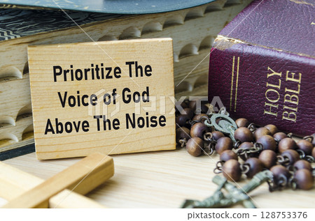 Prioritize The Voice of God Above The Noise text on wooden block with Holy Bible and Holy Rosary background. Christianity concept. Prioritize The Voice of God Above The Noise text on wooden block with Holy Bible and Holy Rosary background. Christianity concept. 128753376