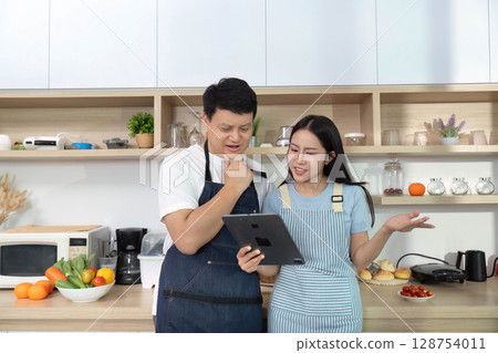 Healthy Cooking Together: Couple Preparing Fresh Ingredients in Modern Kitchen 128754011