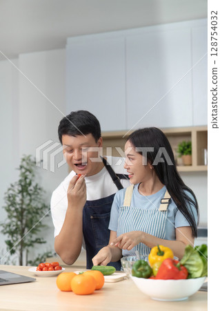 Couple Enjoying Healthy Cooking: Preparing Fresh Ingredients in Kitchen 128754032