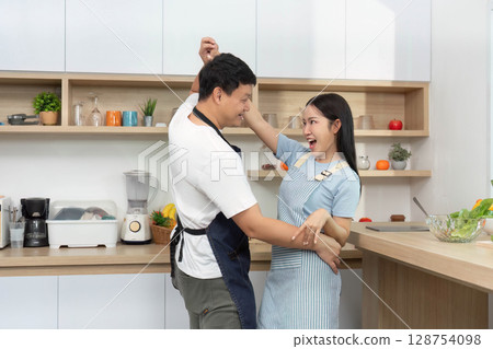 Couple Dancing in Kitchen. Celebrating love and joy through movement. Couple Dancing in Kitchen. Celebrating love and joy through movement. 128754098
