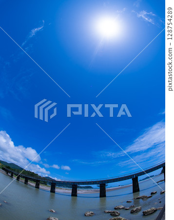 A wide-angle composition looking up at the Nichinan Line railway bridge and the midsummer sun A wide-angle composition looking up at the Nichinan Line railway bridge and the midsummer sun 128754289
