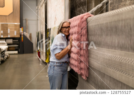 Woman selecting home decor items in a retail store, showcasing genuine emotions and interaction with Woman selecting home decor items in a retail store, showcasing genuine emotions and interaction with 128755527
