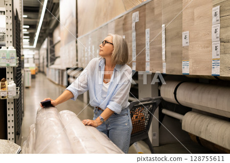 Woman selecting home goods in a retail store, showcasing genuine emotions during shopping adventure Woman selecting home goods in a retail store, showcasing genuine emotions during shopping adventure 128755611