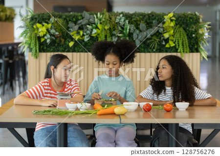 group of multi-ethnic children girls are learning how to cooking with miniature kitchen utensils, teamwork student education up skill make food. 128756276