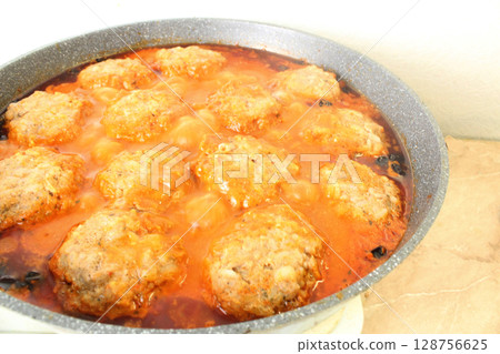 cooking meat in a frying pan. Braising meat products in sauce 128756625