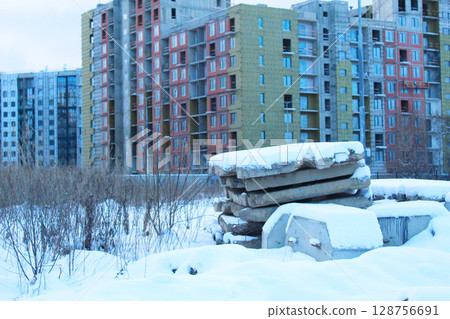 Abandoned building materials are covered with snow. Abandoned buildings 128756691