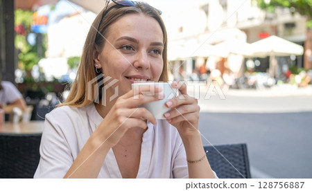 Woman relaxing at an outdoor urban cafe 128756887
