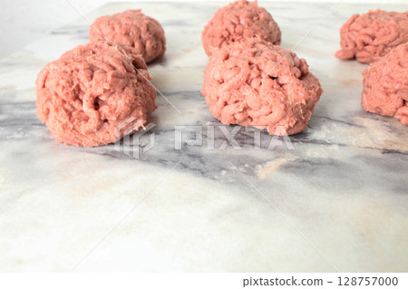 pieces of raw minced meat on a light background. Preparation of semi-finished products pieces of raw minced meat on a light background. Preparation of semi-finished products 128757000