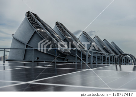Cooling fans are installed on rooftop of large commercial building. Maintaining air circulation and temperature control. Tower air chiller HVAC. 128757417