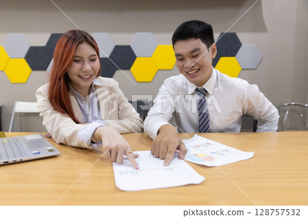Colleagues collaborate over financial documents, pointing out key figures and charts in a contemporary office environment, enhancing teamwork and communication. Colleagues collaborate over financial documents, pointing out key figures and charts in a contemporary office environment, enhancing teamwork and communication. 128757532