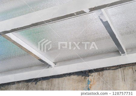 Structural metal beams support composite panel sheet made with insulation pu foam providing efficient thermal barrier often seen construction industrial building 128757731