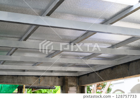 View of robust building structure during construction featuring concrete beams and metal framework. Sandwiched sheet panels likely contain pu foam insulation providing thermal properties 128757733