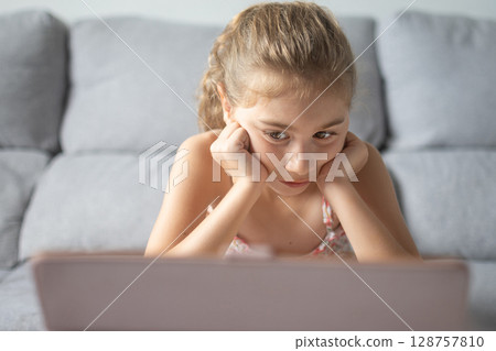 Young Girl Watching Tablet at home 128757810