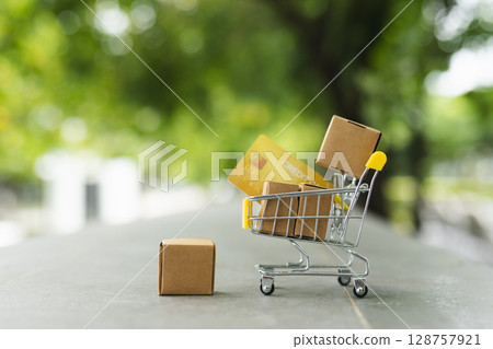 Shopping cart or trolley with Paper box and credit card, copy space. Put product in basket. delivery logistic sell service. Online shopping. Shopping cart or trolley with Paper box and credit card, copy space. Put product in basket. delivery logistic sell service. Online shopping. 128757921
