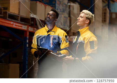 Male worker checking on shelf with digital tablet in warehouse. Professional workers management business delivery import - export online stock for logistics. 128757950