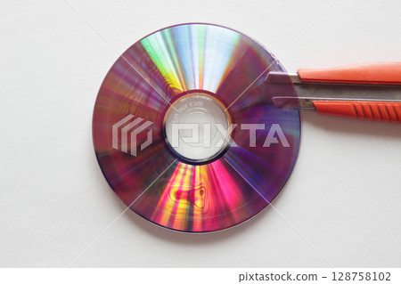 美工刀的刀片卡在 DVD 光碟的接縫處 128758102