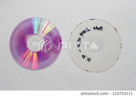 A DVD disc after being split in two and the recording layer peeled off A DVD disc after being split in two and the recording layer peeled off 128758111