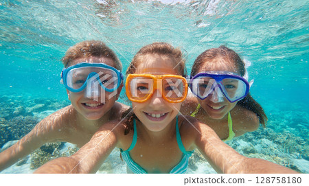 Children enjoying snorkeling and exploring underwater life in a vibrant coral reef while having a fun moment together in clear blue ocean water Children enjoying snorkeling and exploring underwater life in a vibrant coral reef while having a fun moment together in clear blue ocean water 128758180