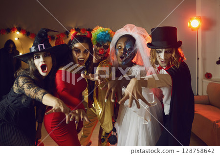 Group portrait of young friends in spooky Halloween costumes saying BOO all together Group portrait of young friends in spooky Halloween costumes saying BOO all together 128758642
