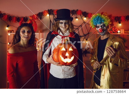 Young people in costumes celebrate Halloween together Young people in costumes celebrate Halloween together 128758664