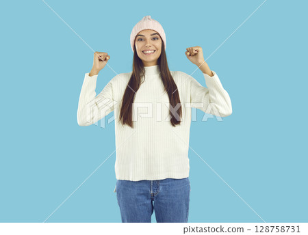Cheerful positive young woman standing with her fists raised 128758731