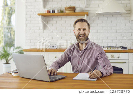 Portrait of smiling businessman work on computer at home 128758770
