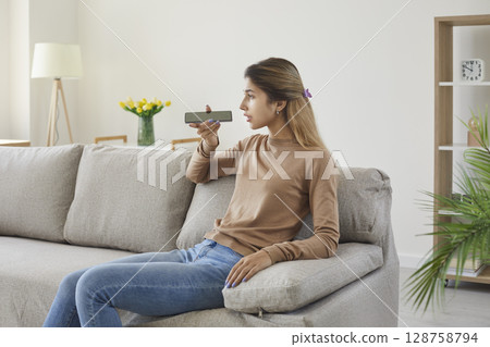 Teenage girl is talking to mobile phone using digital voice application to search Internet. 128758794