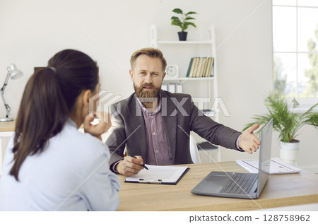 Male manager provides advice to female client and acquaints her with terms of contract. Male manager provides advice to female client and acquaints her with terms of contract. 128758962
