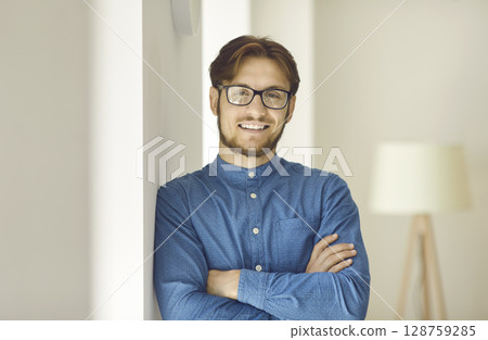 Portrait of happy and successful young businessman looking at camera with confident expression. Portrait of happy and successful young businessman looking at camera with confident expression. 128759285