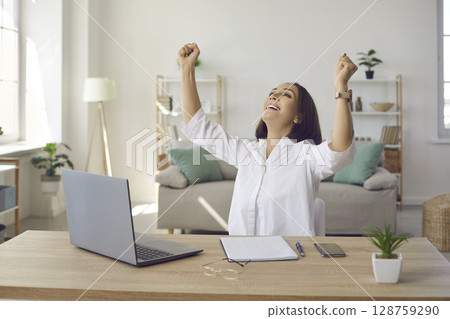 Businesswoman feeling happy and satisfied after finishing work on her laptop computer 128759290