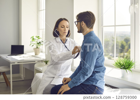 Young male patient gets his breath or heartbeat checked during his visit to clinic 128759300