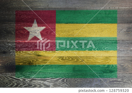 Togo flag on rustic old wood surface background 128759320
