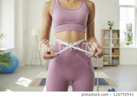 Slim woman who's been working out shows how many centimeters she's lost off her waist 128759541