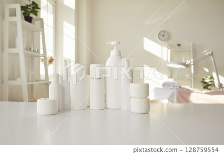 Set of different white clean bottles with natural cosmetics standing on table of beauty salon. 128759554