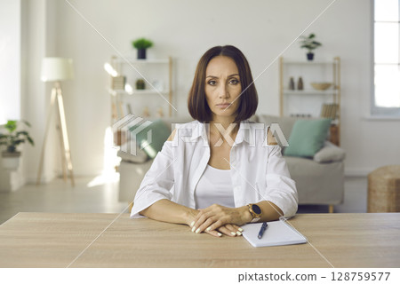 Serious woman company manager conducts online interview or video meeting with her clients. Serious woman company manager conducts online interview or video meeting with her clients. 128759577
