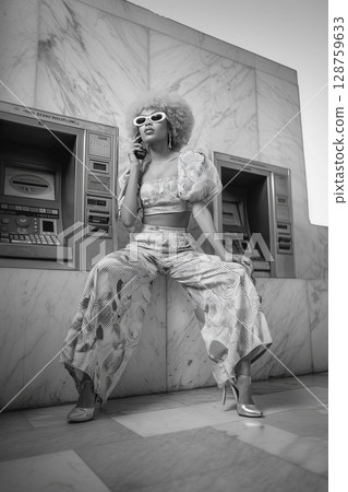 A woman in a white outfit sits in front of a pay machine A woman in a white outfit sits in front of a pay machine 128759633