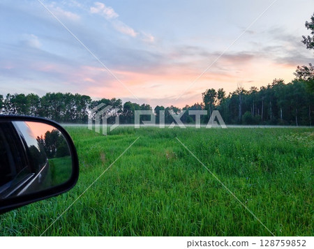 Beautiful summer landscape and peaceful view in the rainy season. vast green fields stretch out in front of us. evening, covered with thick fog 128759852