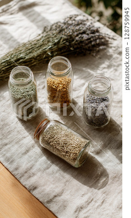 Exploring organic herbs in glass jars with dried flowers on a rustic table setting, highlighting natural alternatives for homeopathy and cosmetics 128759945