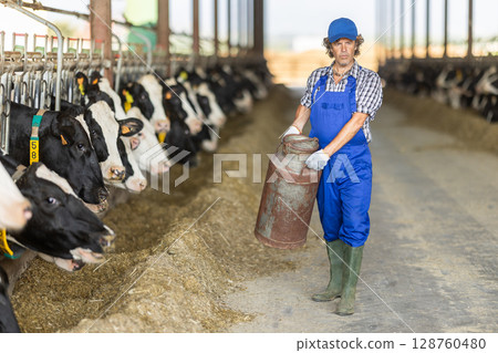 man holding a gas cylinder on a farm man holding a gas cylinder on a farm 128760480