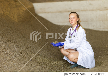 Female veterinarian checking pelleted livestock feed Female veterinarian checking pelleted livestock feed 128760493