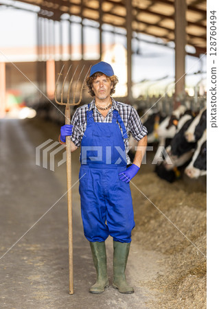 Portrait of male farm employee in blue jumpsuit 128760494
