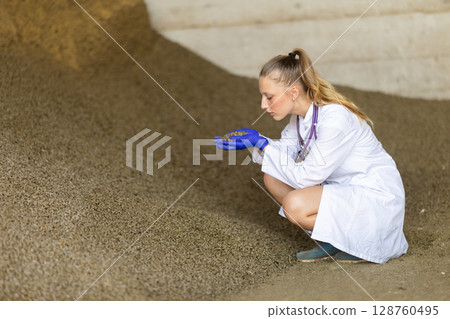 Young female vet checking granulated feed Young female vet checking granulated feed 128760495