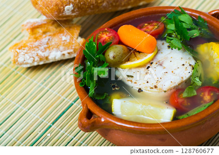 Fisherman's broth cooked with boiled pollock, carrots, corn and greens Fisherman's broth cooked with boiled pollock, carrots, corn and greens 128760677
