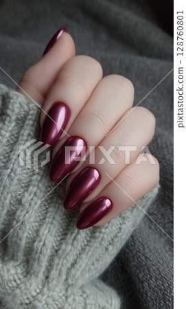 Close-up of a metallic manicure in the color of fuchsia on long oval nails. 128760801