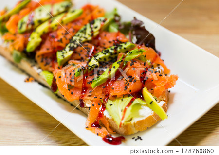 Image of salmon toast with lettuce, avocado and cheese 128760860
