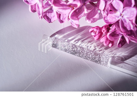 Cosmetic pipette with serum and lilac flowers. 128761501